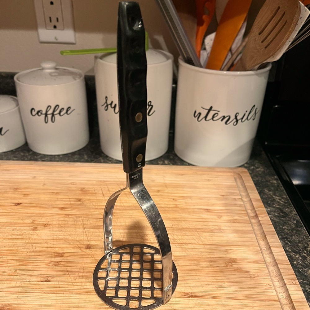 MCM vintage Potato Masher Stainless Steel and plastic wood grain/black handle 9”